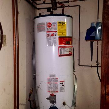 Photo of a hot water heater with pipes and maintenance stickers, exemplifying plumbing work by L & S Plumbing in Burlingame.