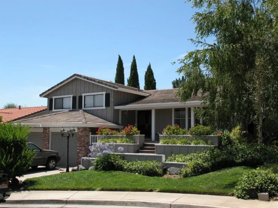 A well-maintained house with a tiled roof surrounded by manicured landscaping, highlighting Los Gatos Roofing's work in San Jose.