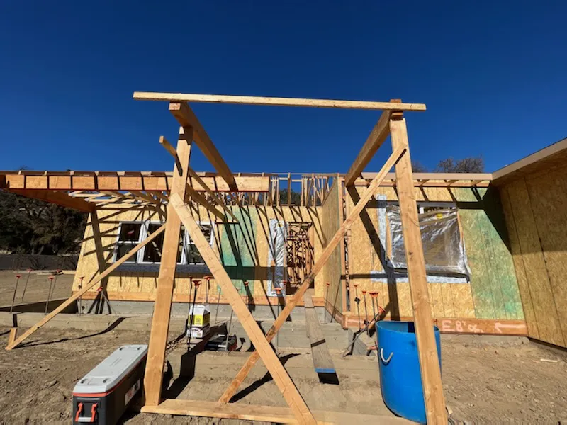 Wooden framework and partially constructed house by Mana Construction Inc. under a clear blue sky in Vallejo.