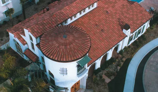 Aerial view of a house in Fremont featuring a red tile roof, installed by Marco Roofing, showcasing a blend of traditional and modern architectural elements.