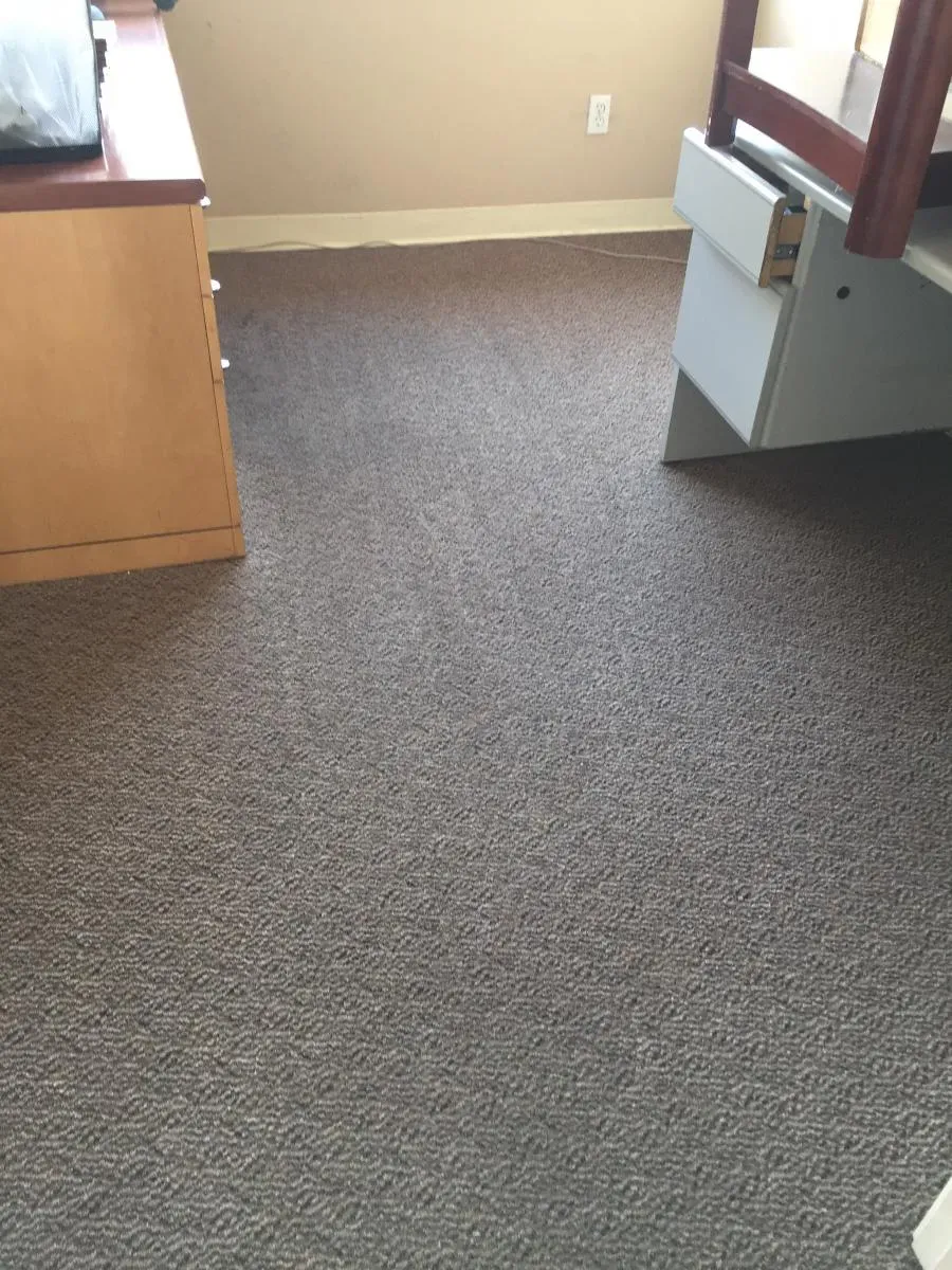 A clean carpeted room featuring a desk and chair, showcasing the results of professional cleaning by Maximum Carpet Cleaning in Pleasant Hill.