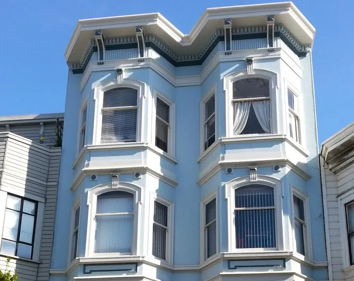 A beautifully painted blue Victorian-style building in San Francisco, showcasing Metro Painting Co.'s craftsmanship with detailed window trims and decorative elements.