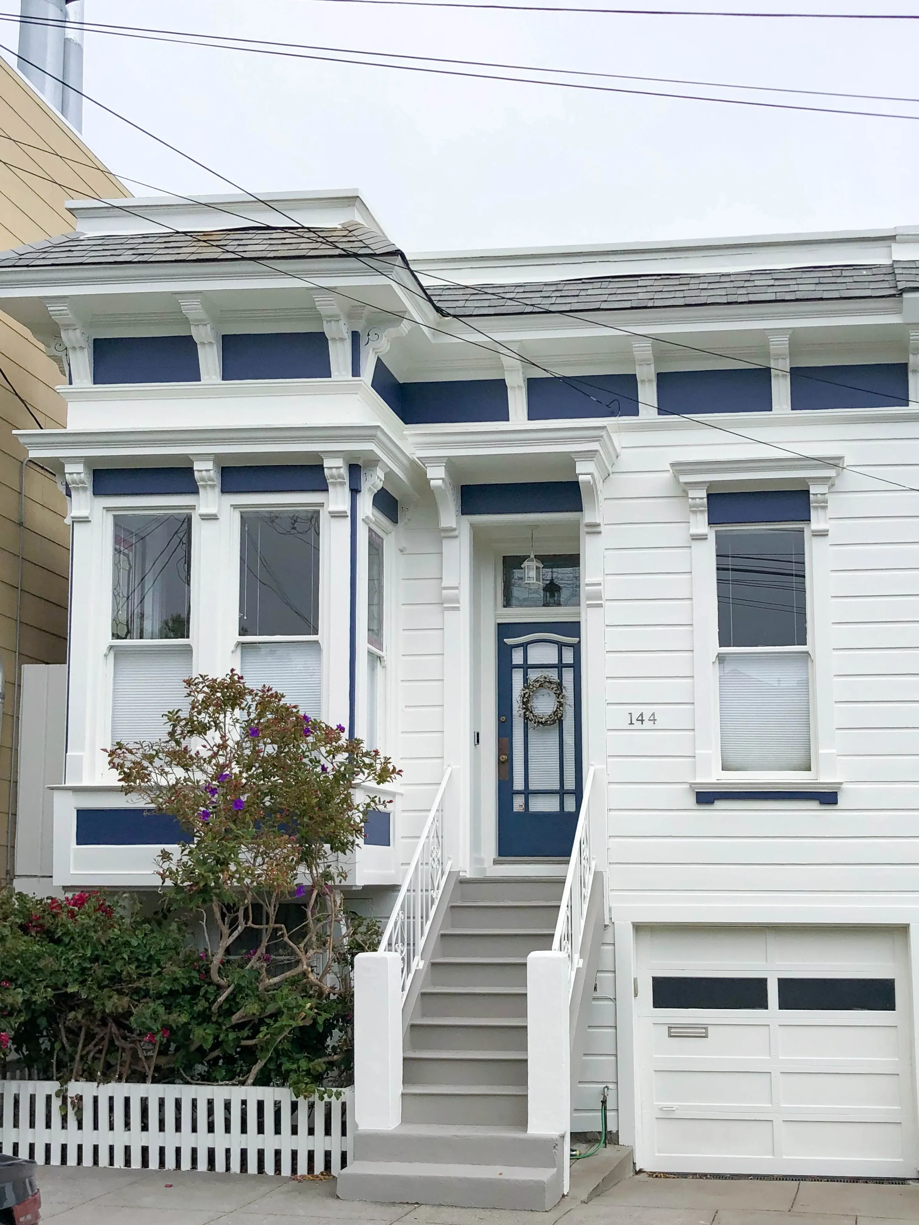 "A freshly painted Victorian-style house in San Francisco with blue and white colors, highlighting the work of Michael Sack Painting, Inc."