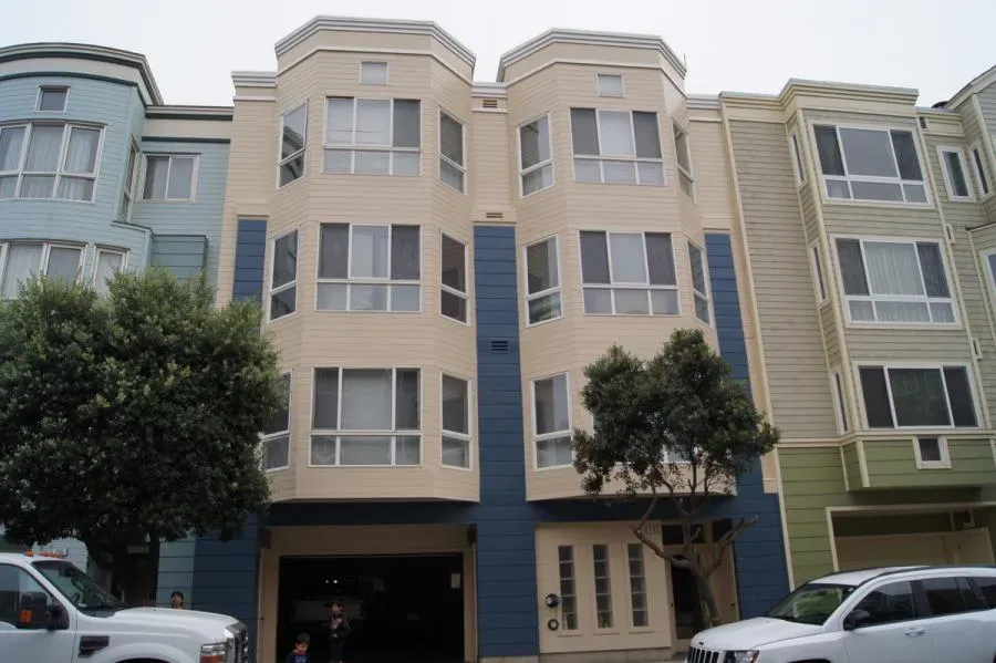 A multi-story building in San Francisco, showcasing a freshly painted facade with neutral tones, exemplifying the quality work of Michael Sack Painting, Inc.