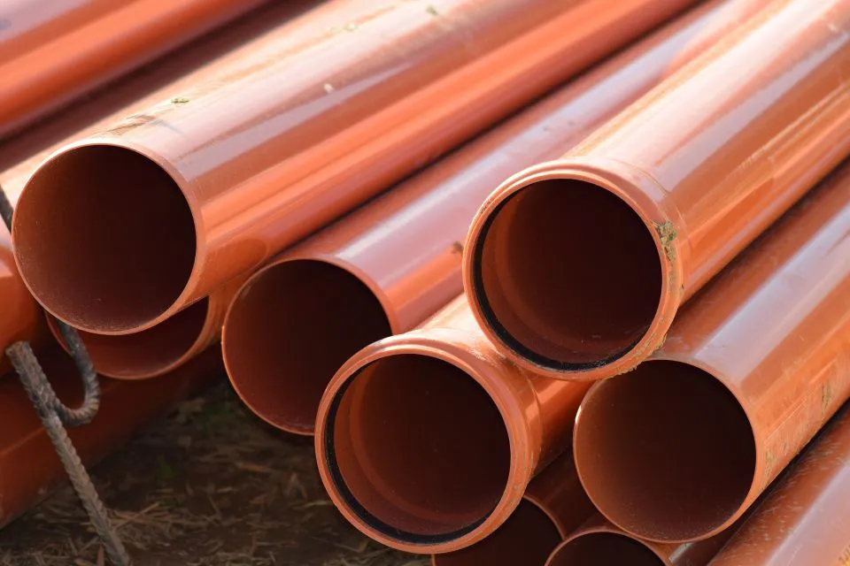 A stack of orange PVC pipes representing the quality materials used by Mike Testa Plumbing, Inc. in San Rafael.