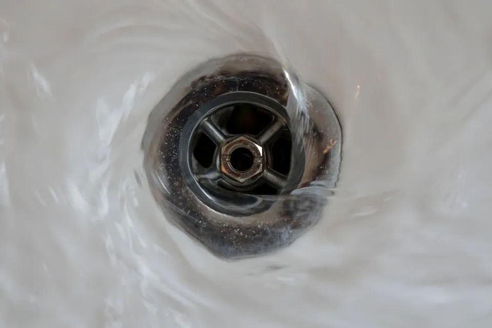 "Close-up of water swirling down a drain, representing plumbing services by Mike Testa Plumbing, Inc. in San Rafael."