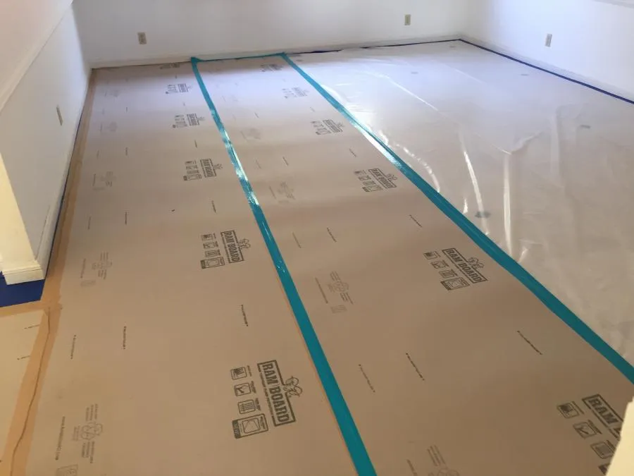 "Floor covered with protective paper and plastic sheeting, secured with blue tape, during a restoration project by NBE Property Restoration in Santa Rosa."