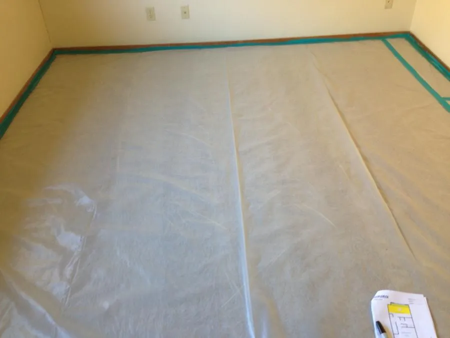 "A room floor covered with protective sheeting and blue tape along the edges, showing preparation work by NBE Property Restoration in Santa Rosa."