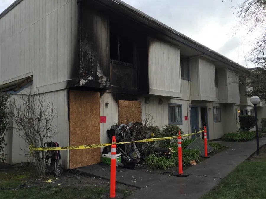 Fire-damaged building in Santa Rosa with boarded windows and caution tape, managed by NBE Property Restoration.