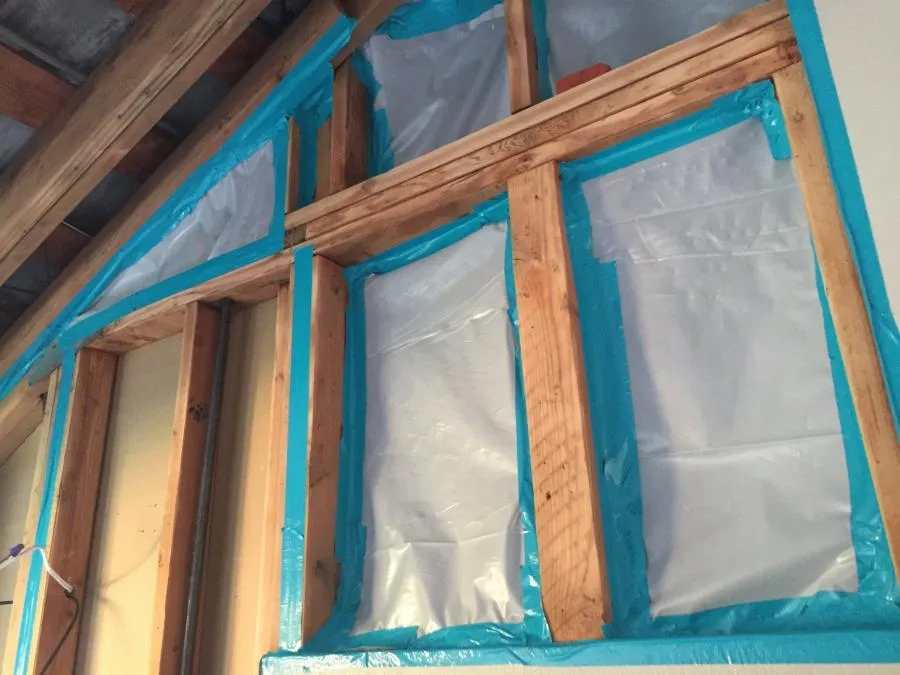 An image showing insulated wall sections with wooden beams and plastic sheeting, highlighting the restoration work by NBE Property Restoration in Santa Rosa.