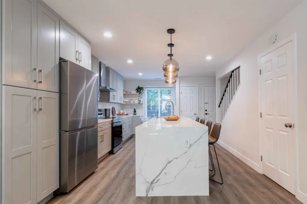 Modern kitchen interior featuring a marble island, stainless steel appliances, and sleek cabinetry by NuHome Remodeling, located in San Jose.