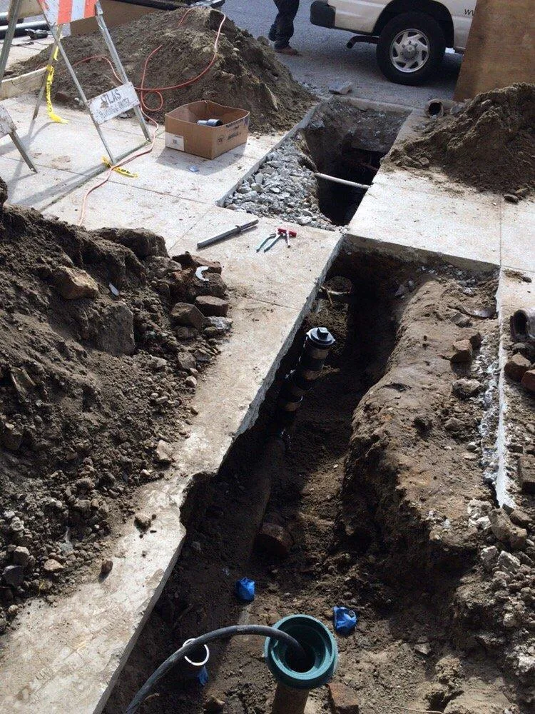 Image of a construction site with open trenches revealing plumbing work in progress, tools, and materials, demonstrating the work of One Source Plumbing and Rooter, Inc. in San Francisco.