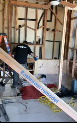 A person working on a bathroom remodel with exposed wall studs and tools, representing Oro Pro Plumbing, Inc. in South San Francisco.