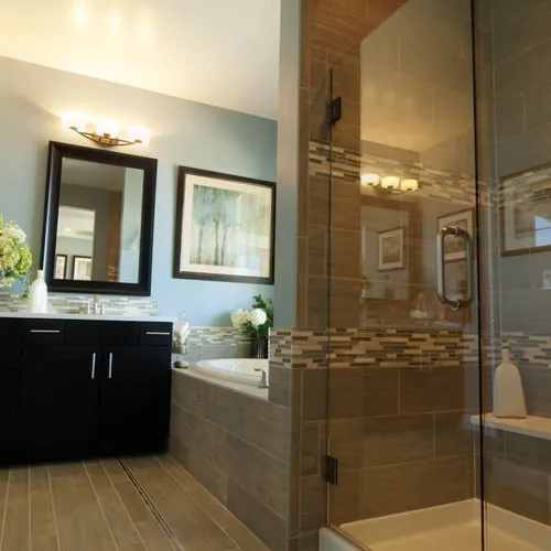 A modern bathroom featuring elegant tile work and a glass shower, highlighting the quality flooring by Pacific Coast Carpet, Inc. in Concord.