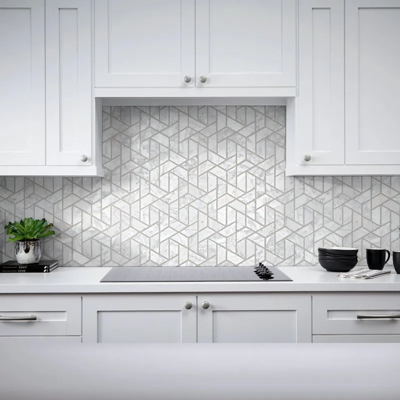 A modern kitchen featuring white cabinetry and a geometric-pattern backsplash, highlighting clean, contemporary design elements.