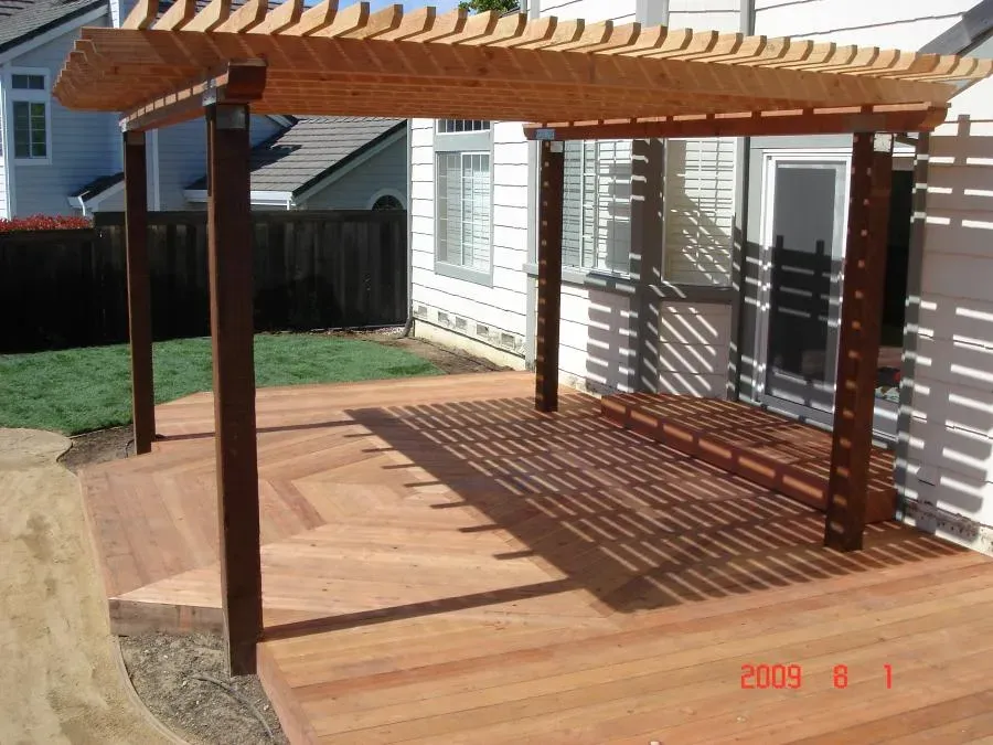 A wooden pergola and deck in a backyard, showcasing Pacific Landscaping's craftsmanship in Walnut Creek.