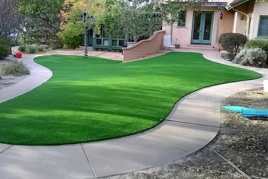 A neatly landscaped yard with vibrant green grass and smooth, curving pathways, designed by Pacific Landscaping & Tree Service Inc. in Pacific Grove.