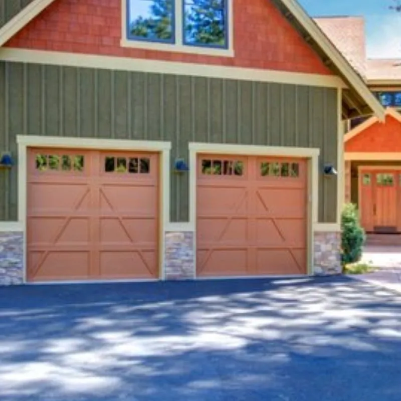 Two closed brown garage doors with decorative paneling on a residential house, installed by Palms Garage Doors in San Jose.