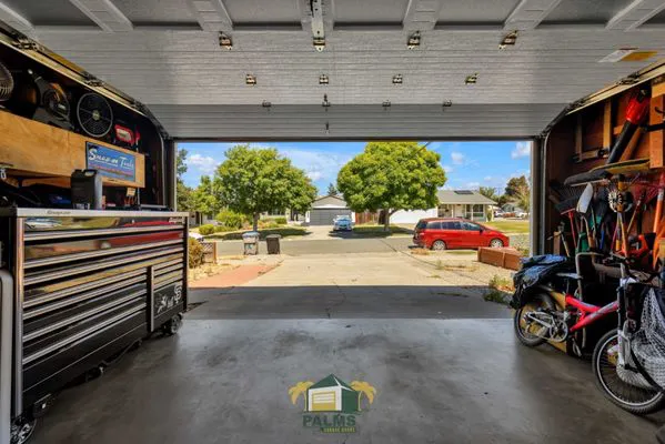 Open garage with various tools and bicycles organized neatly, showcasing the clean and functional design by Palms Garage Doors in San Jose.