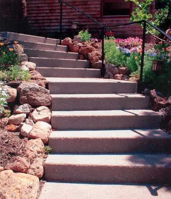 Concrete steps surrounded by rocks and flowers, built by Paradigm Concrete & Construction, Inc. in Antioch.