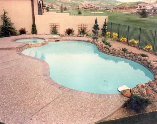 An elegantly designed swimming pool with surrounding stonework and landscaping, created by Paradigm Concrete & Construction, Inc. in Antioch.