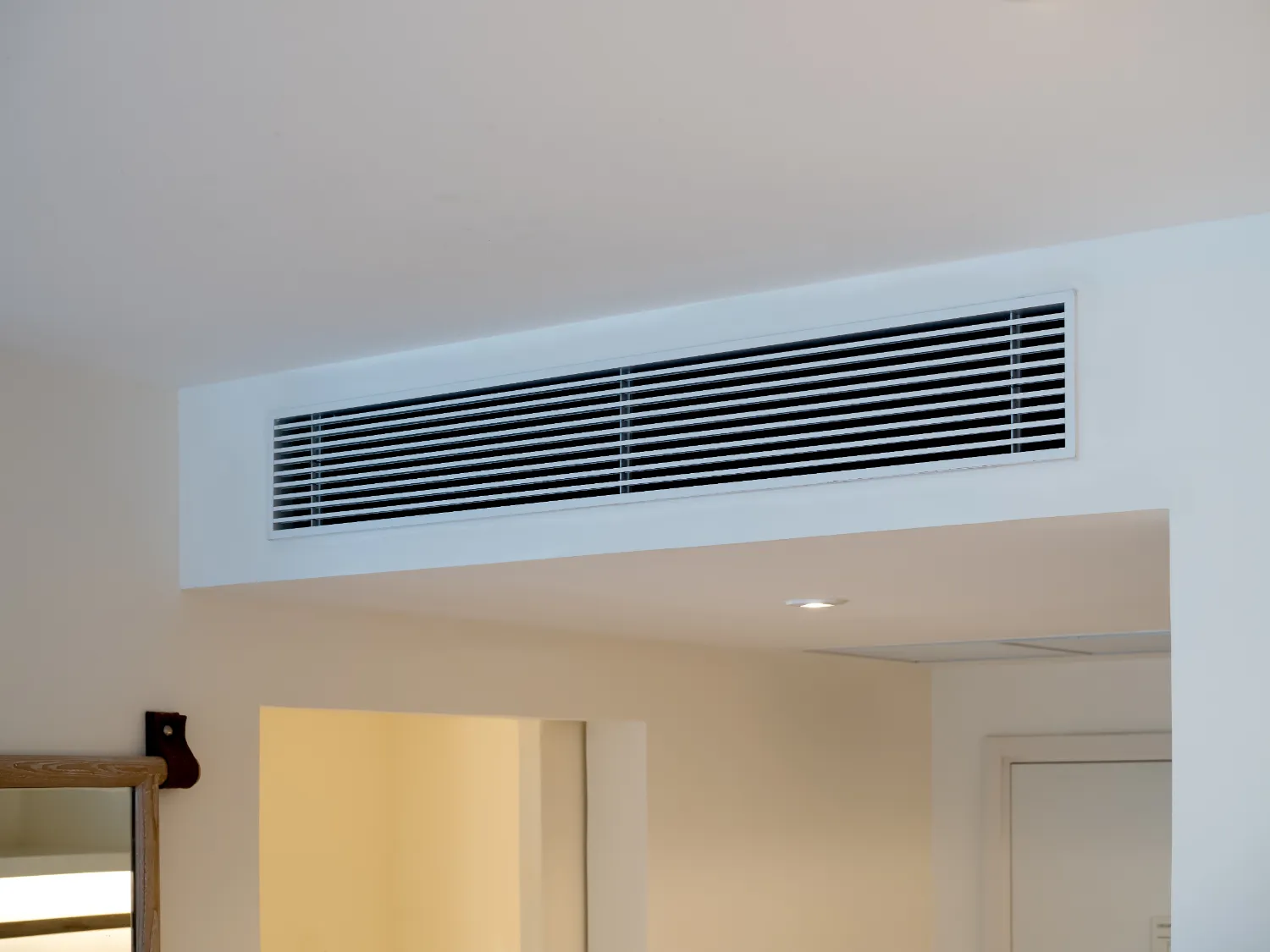 A modern air vent installed on a white wall, representing efficient airflow, provided by Paso Robles Plumbing, Heating, and Air in Paso Robles.