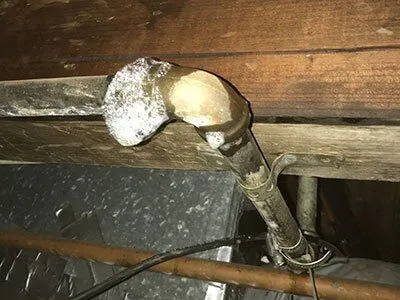 Image of a corroded plumbing pipe under a wooden floor, showing significant damage and need for repair, representing the type of issues Plumbtree Plumbing and Rooter Inc. handles in Santa Clara.