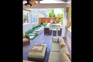 Modern outdoor patio area with comfortable seating, a stone path, and a landscaped garden, designed by Pool & Landscape Development in Brentwood.