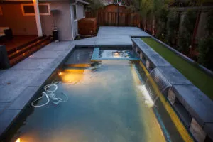 A well-lit modern swimming pool featuring clean lines, constructed by Pool & Landscape Development in Brentwood.