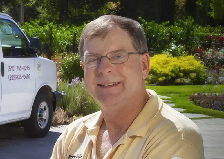 "A person smiling outdoors with a Precision Cleaning Services van in the background, set in a lush garden area."