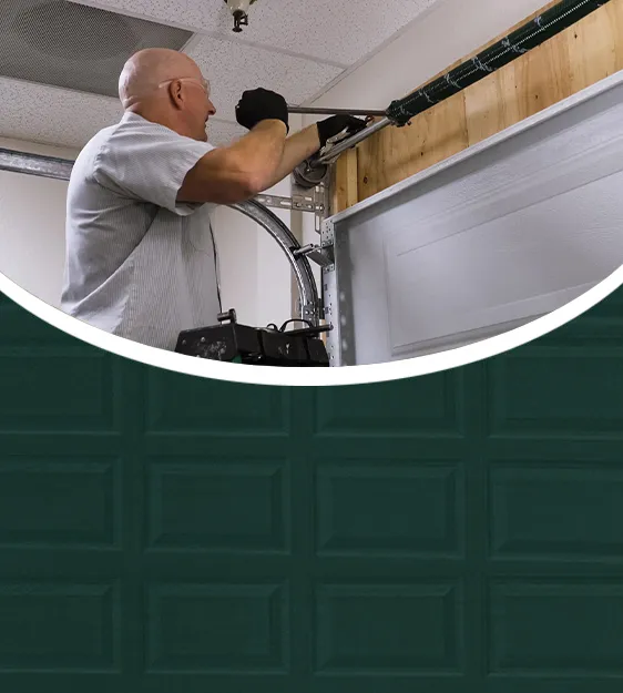 A technician from Precision Door Services of the Bay Area working on a garage door mechanism in Hayward.