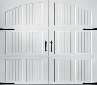 A white garage door with four panels featuring vertical grooves and black decorative hardware.