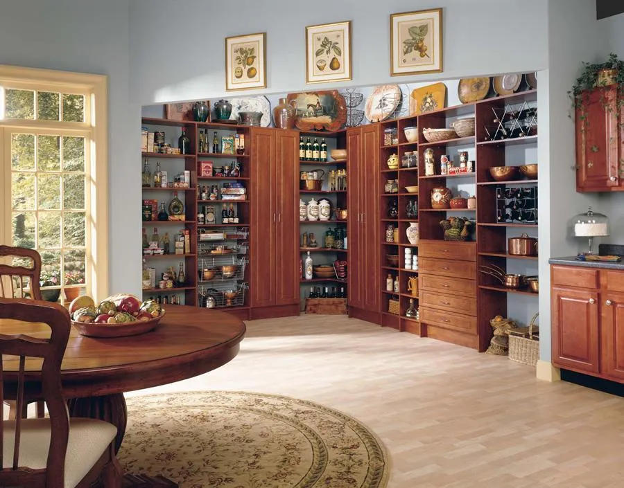 A kitchen pantry with neatly organized wooden shelves filled with bottles, jars, and dishes, featuring PremierGarage's storage solutions in San Mateo.