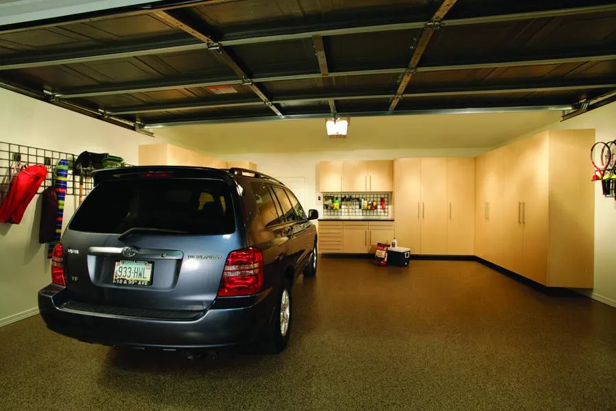 A well-organized garage featuring a parked car, storage cabinets, wall-mounted organizers, and a clean, polished floor in San Mateo by PremierGarage.