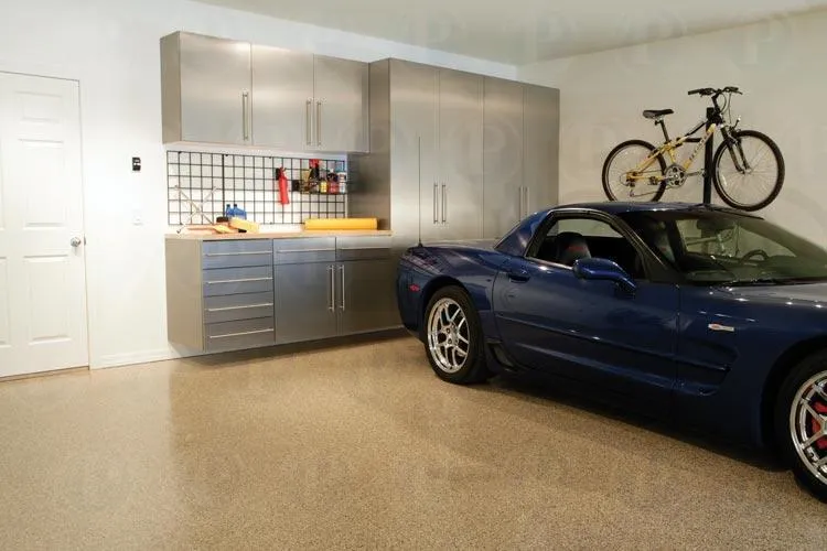 A well-organized garage by PremierGarage in San Mateo, featuring metallic cabinets, a mounted bicycle, and a parked blue sports car.