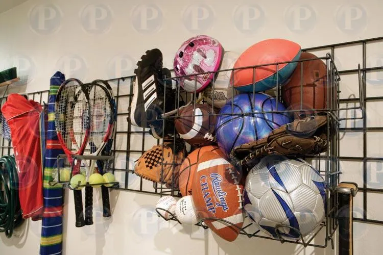 "A well-organized garage wall with sports equipment like rackets, balls, and gloves efficiently stored, showcasing PremierGarage's organization solutions in San Mateo."
