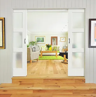 A modern living room with white sliding doors from Quality Windows & Doors, Inc., featuring a bright interior space in Pleasanton.