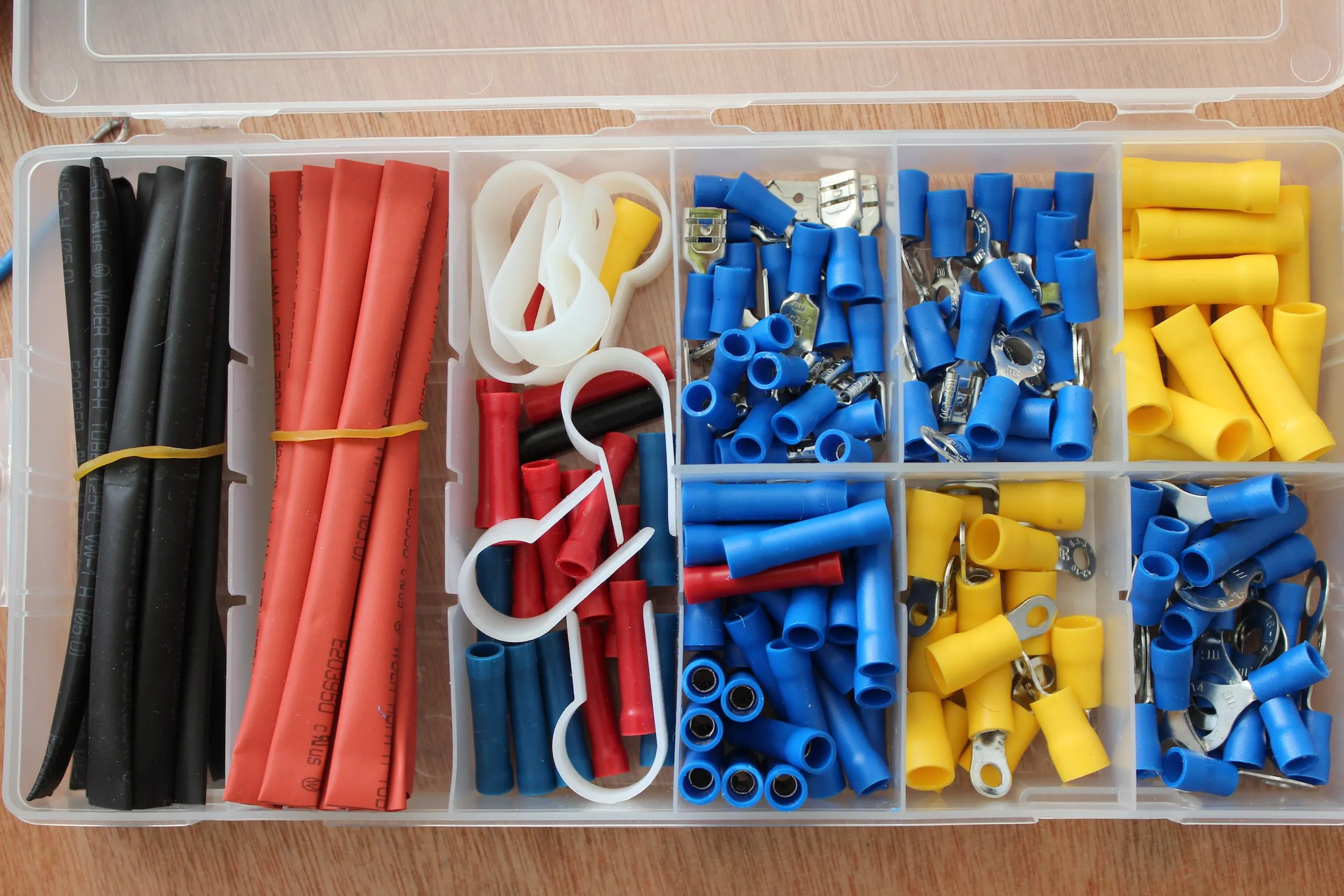 A neatly organized plastic box containing various colored electrical components, highlighting REFCorp's product offering in Daly City.