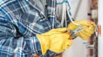 An electrician wearing yellow gloves works on wiring in a panel, representing Reyff Electric, Inc. in Rohnert Park.
