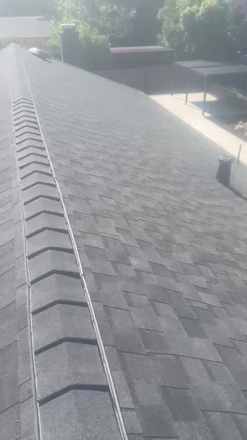 A close-up view of a shingled rooftop with sunlight casting shadows, showcasing the precise installation by Roof-Life Construction in San Ramon.