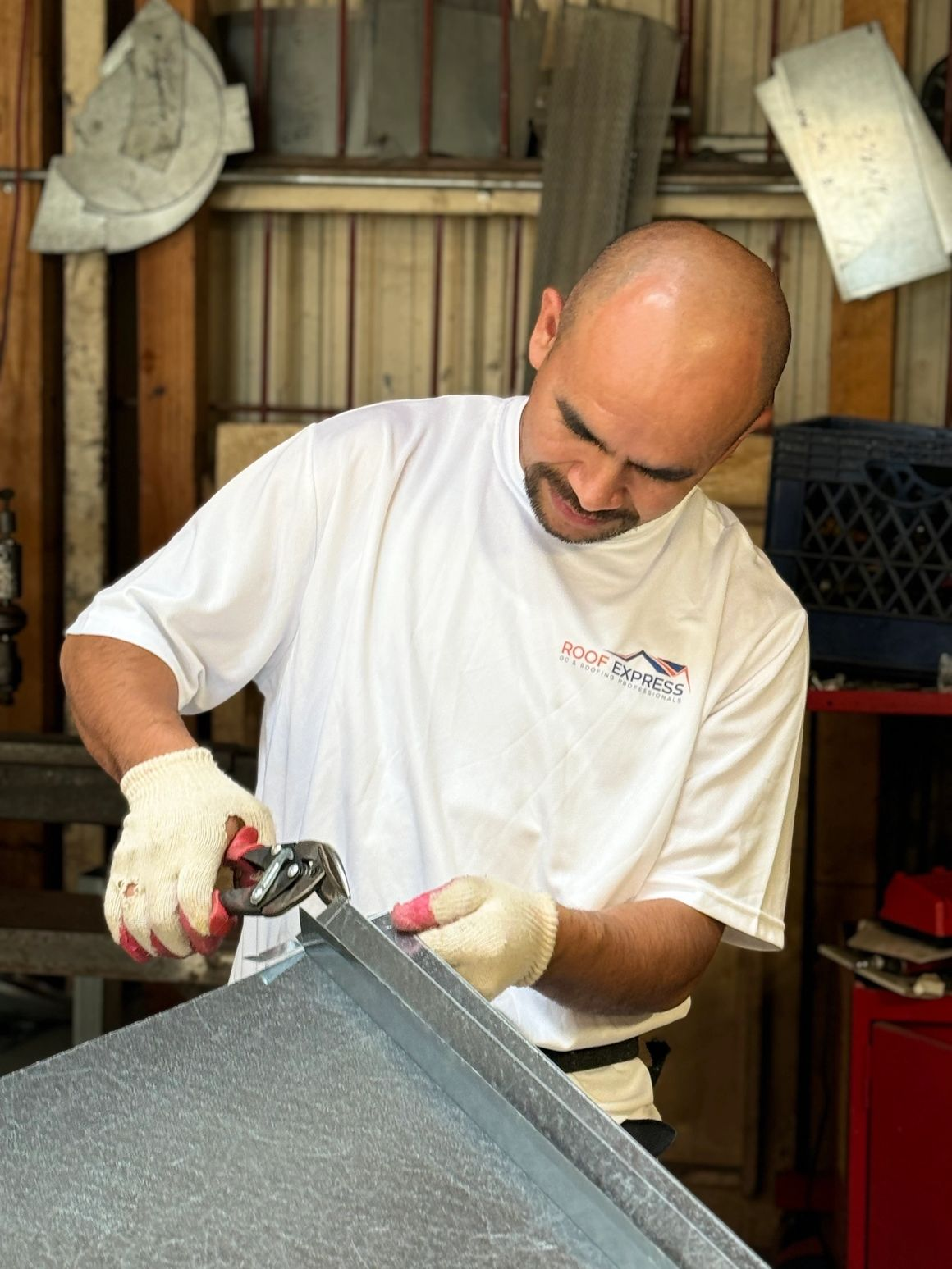 A craftsman from Roof Express in San Francisco working on metal roofing with tools in hand, demonstrating attention to detail.