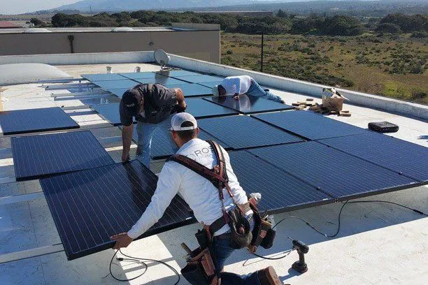 Workers from Ross Roofing & Construction, Inc. installing solar panels on a rooftop in Marina, showcasing a commitment to sustainable energy solutions.