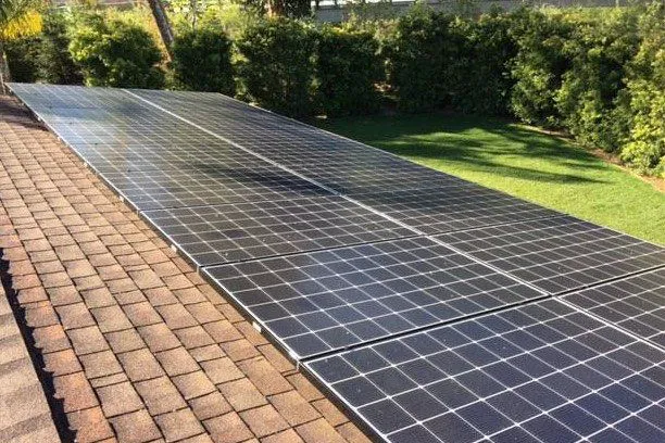 Solar panels installed on a residential roof surrounded by greenery, representing the eco-friendly solutions provided by Ross Roofing & Construction, Inc. in Marina.