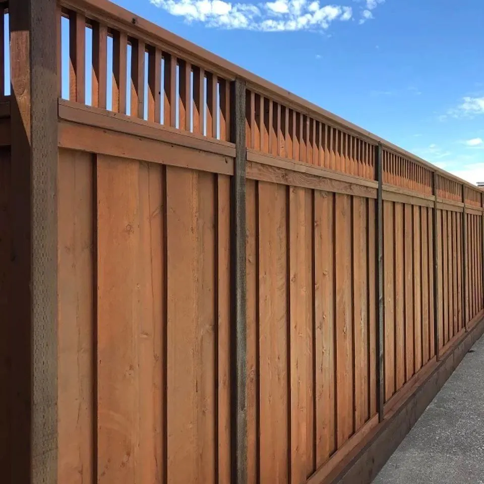 A long wooden fence with vertical slats crafted by SF Craftsman, Inc. in San Francisco, set against a blue sky with clouds.