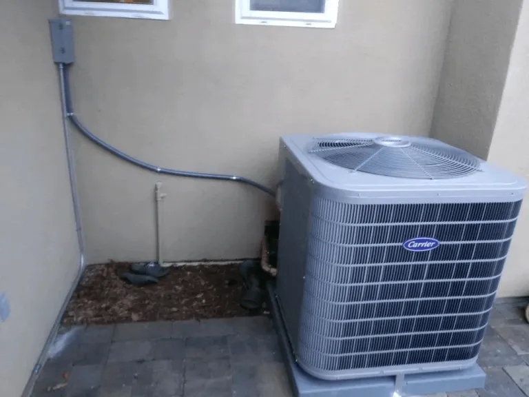 "An outdoor HVAC unit next to a beige wall, installed by SanJoseHeating&Cooling in SanJose."