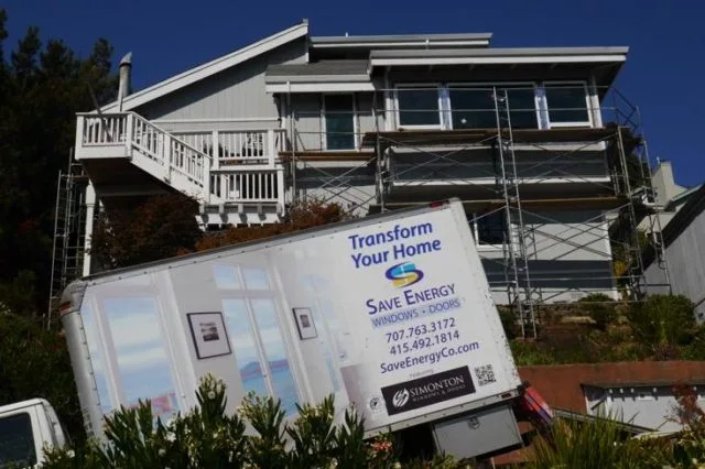 A large Save Energy Company truck is parked outside a house undergoing renovations in Petaluma, with scaffolding visible and a focus on energy-efficient improvements.