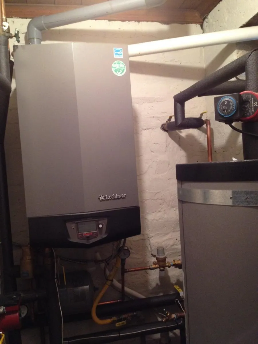 A well-maintained Lochinvar heating system installed in a utility room, featuring pipes and gauges, serviced by Savior Plumbing, Inc. in Pleasanton.