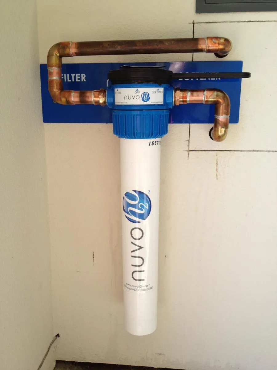 A sophisticated water filtration system with blue and white labeling, showcasing copper piping and a blue filter labeled NuvoH2O, installed for optimal plumbing.