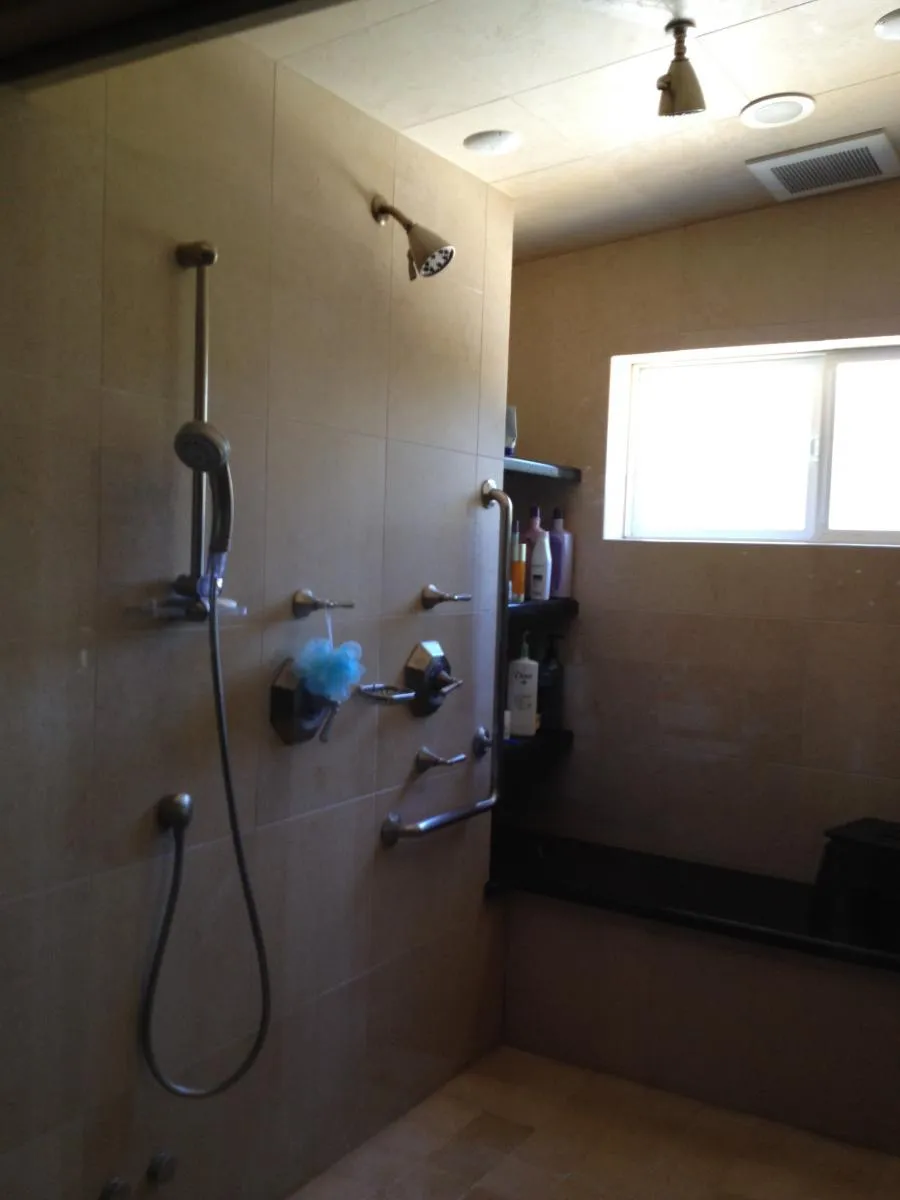 An elegant bathroom shower setup with multiple shower heads and support bars, installed by Savior Plumbing, Inc. in Pleasanton.