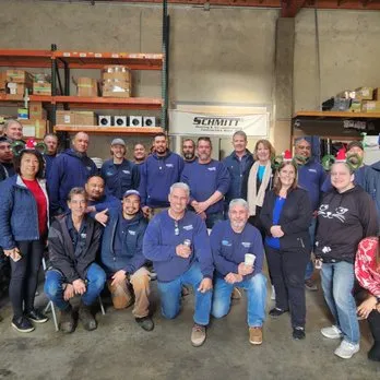 Group photo of the Schmitt Heating Company, Inc. team in San Francisco, standing together in a warehouse setting.
